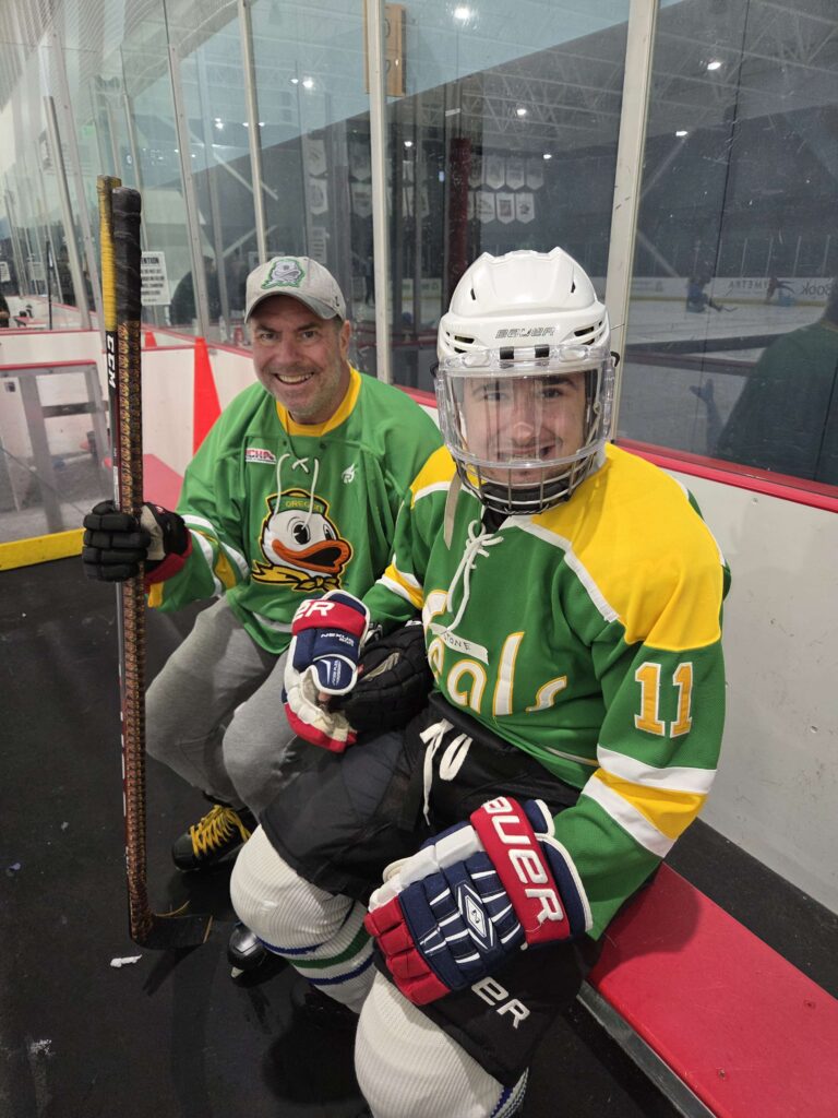 Stone and his dad, David Kaufer, share a rink-side moment after practice—family partnership in action.